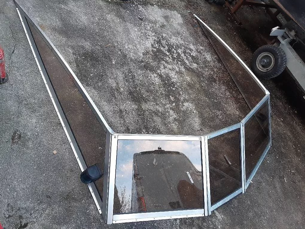 Parabrisas de bateau démonté sur sol en béton