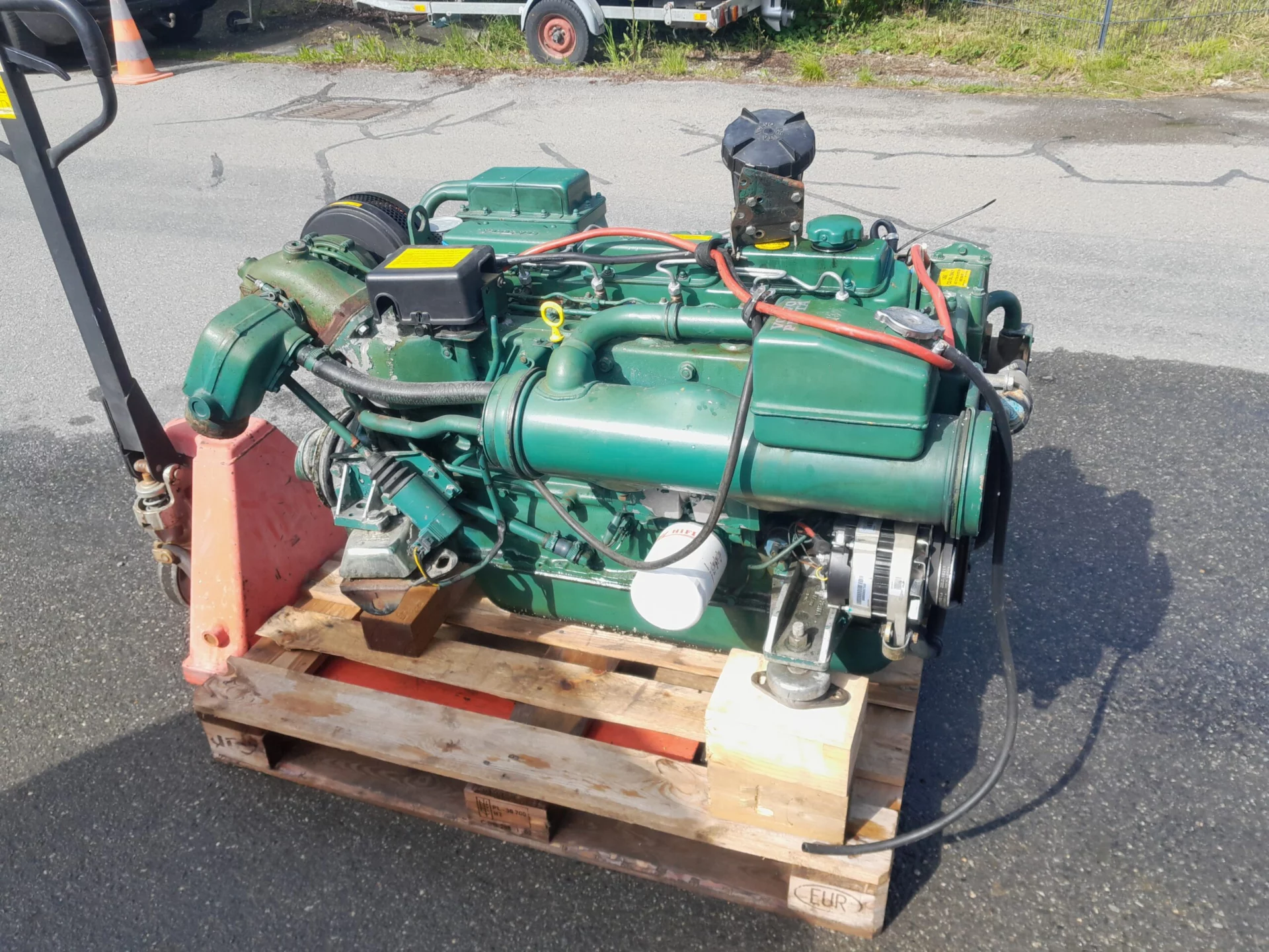 Moteur diesel vert posé sur une palette en bois à l'extérieur