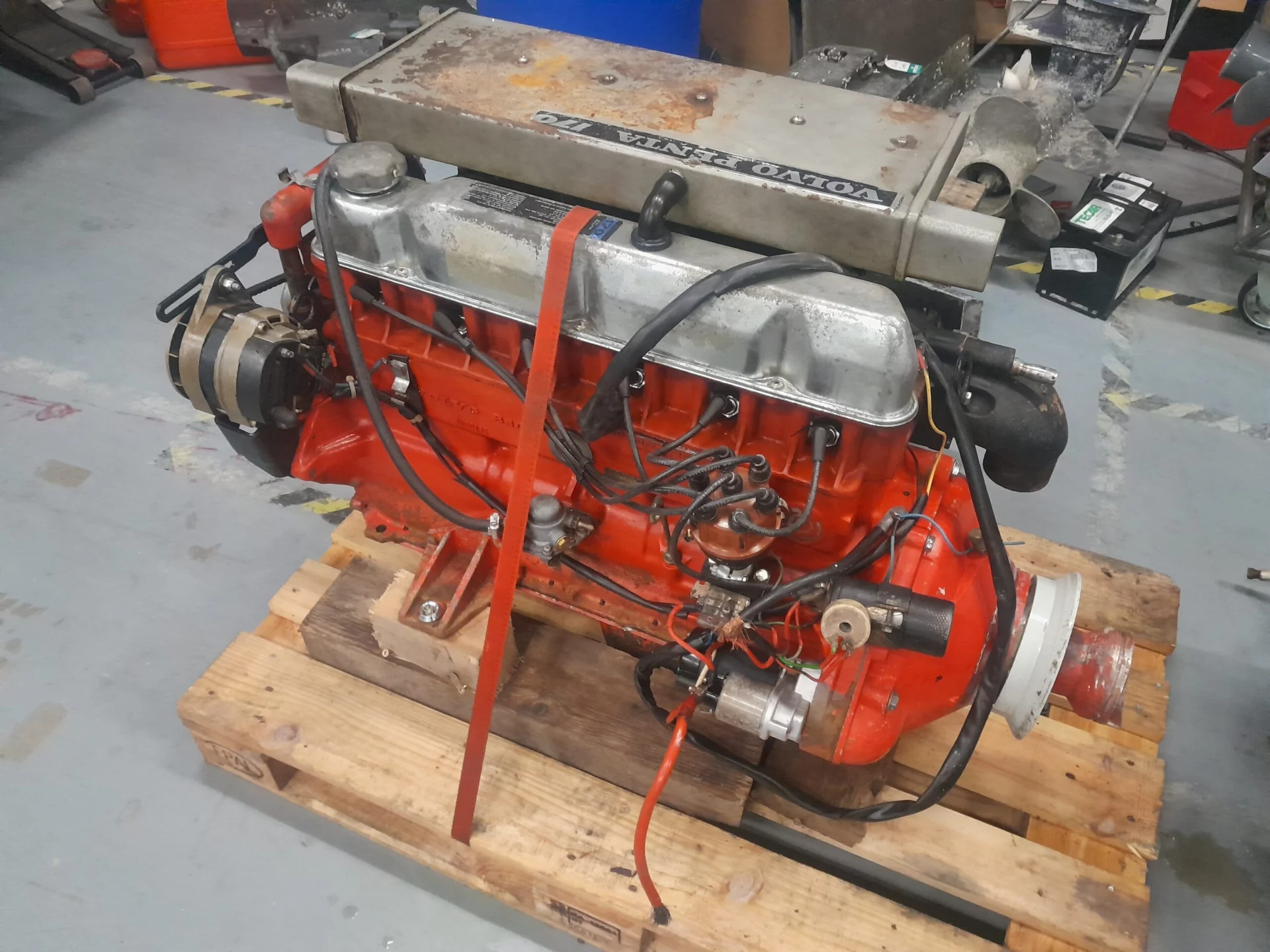 Moteur Volvo Penta rouge sur palette en atelier mécanique.