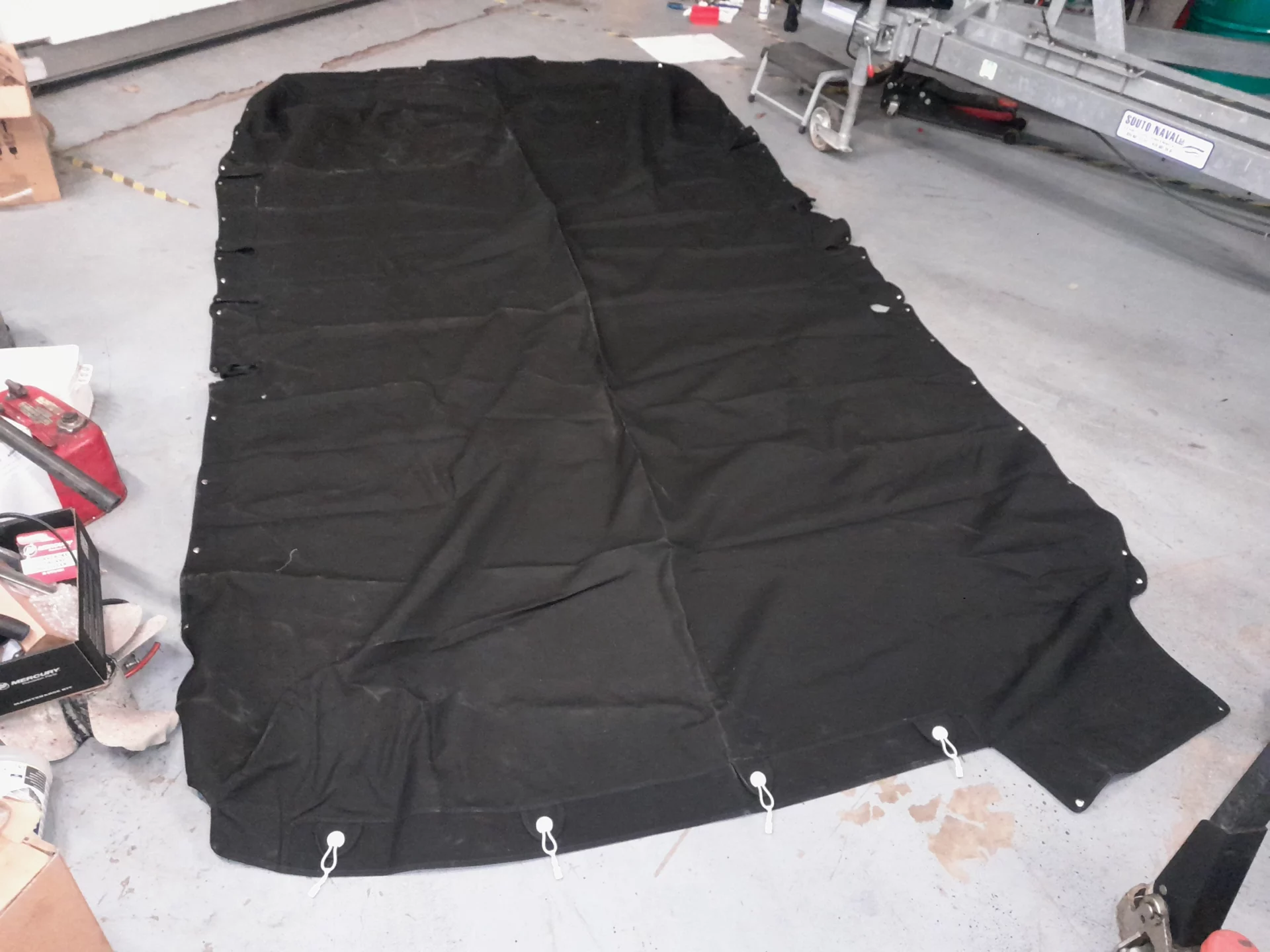 Grande bâche noire étalée sur le sol d'un atelier